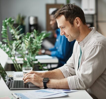 Man Working at Computer in Office Side View