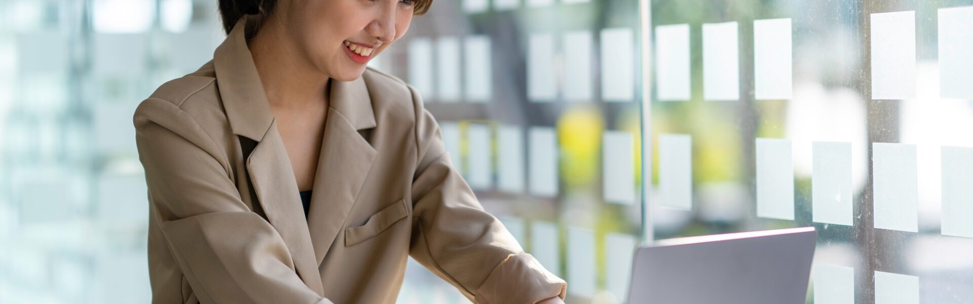 Young businesswoman typing an e-mail on laptop at home office.