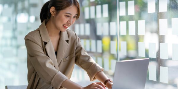 Young businesswoman typing an e-mail on laptop at home office.