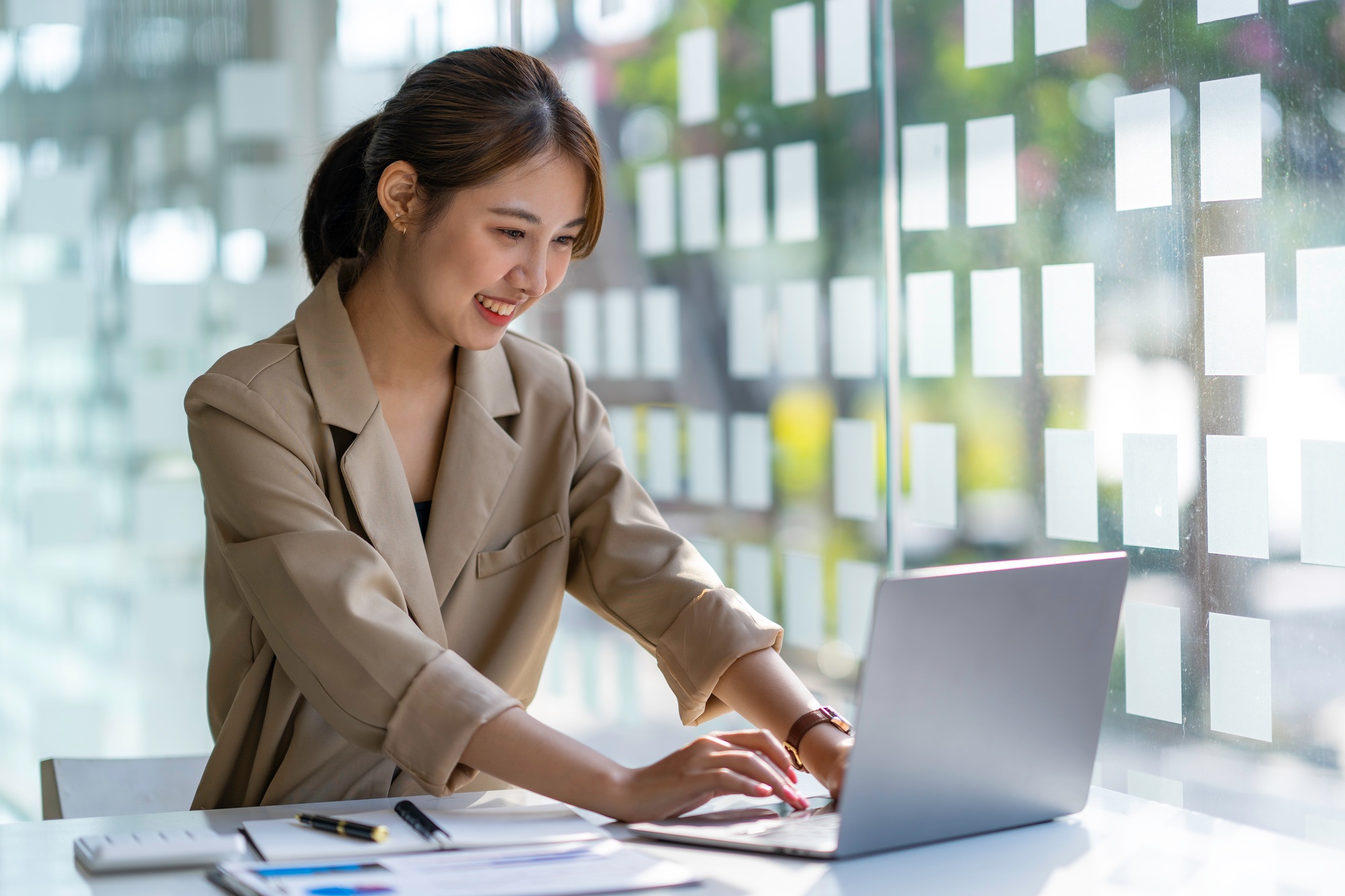 Young businesswoman typing an e-mail on laptop at home office.
